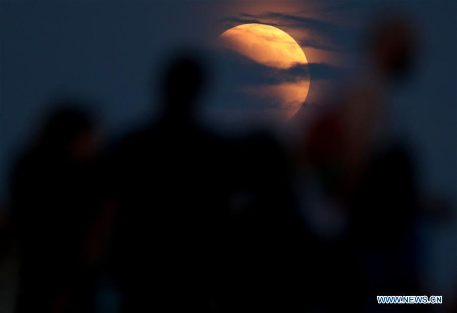 People watch the longest total lunar eclipse of the century at Jarun Lake in Zagreb, capital of Croatia, on July 27, 2018. (Xinhua/Igor Kralj)