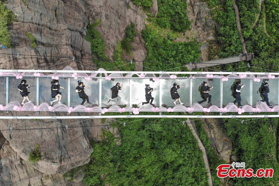 Students take creative graduation photos on a glass-bottom bridge in the Shiniuzhai National Geological Park in Pingjiang County, Central China's Hunan Province, June 27, 2018. The transparent bridge is suspended between two cliffs, 180 meters above ground. (Photo: China News Service/Yang Huafeng)