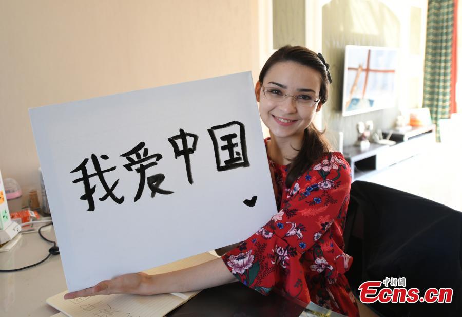 Valentina shows her calligraphy work at her home in Changchun, Northeast China’s Jilin province. (Photo: China News Service/ Zhang Yao)