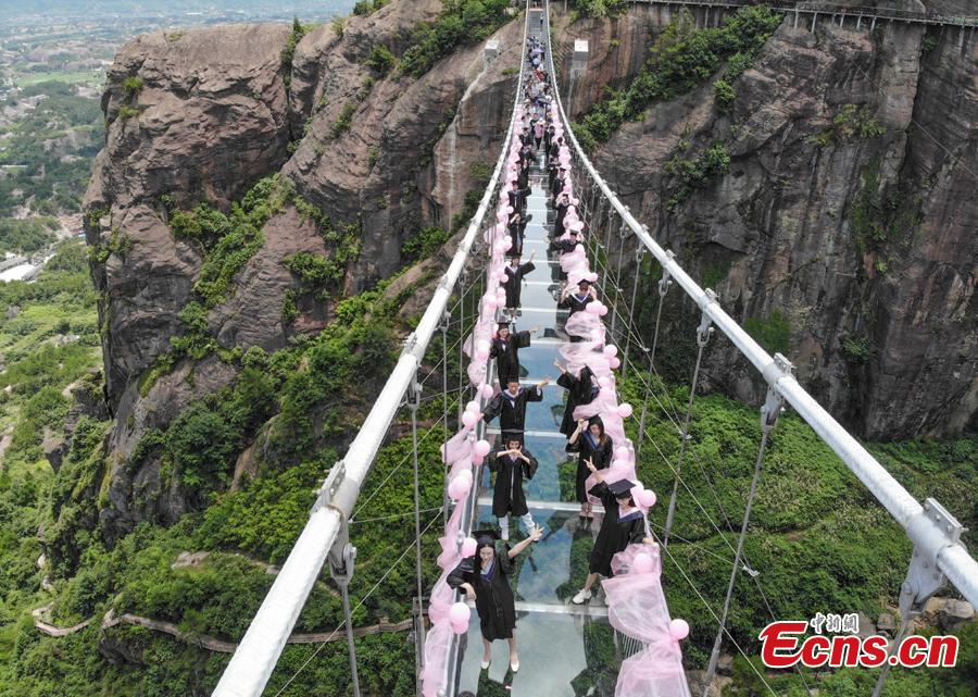 Students take creative graduation photos on a glass-bottom bridge in the Shiniuzhai National Geological Park in Pingjiang County, Central China's Hunan Province, June 27, 2018. The transparent bridge is suspended between two cliffs, 180 meters above ground. (Photo: China News Service/Yang Huafeng)