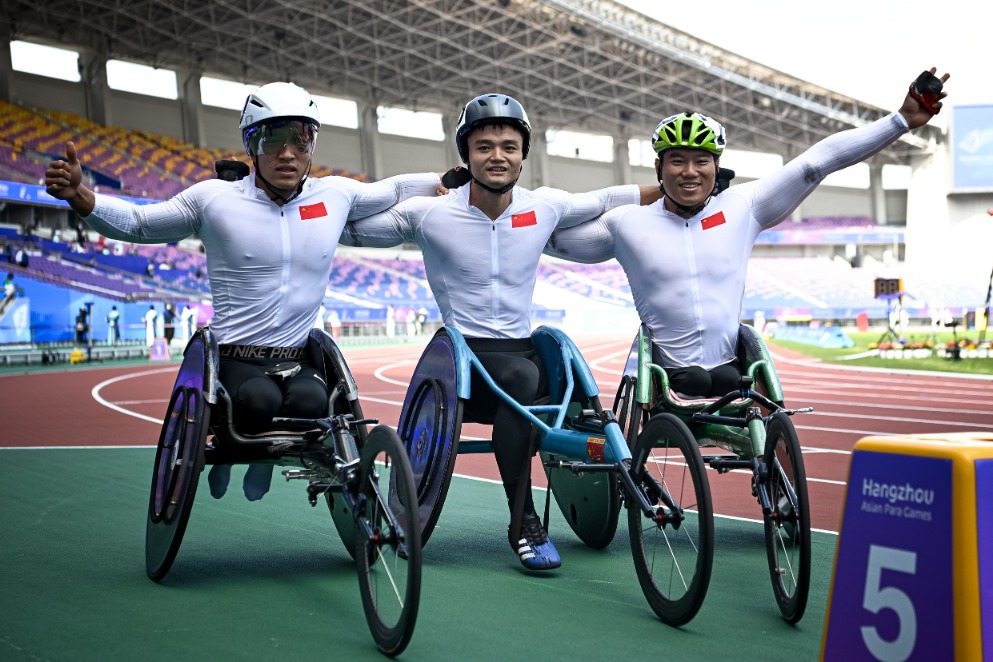 10月24日,中国选手代云强(右)、马卓(左)与胡洋在男子1500米T54级决赛后合影。新华社记者江汉摄