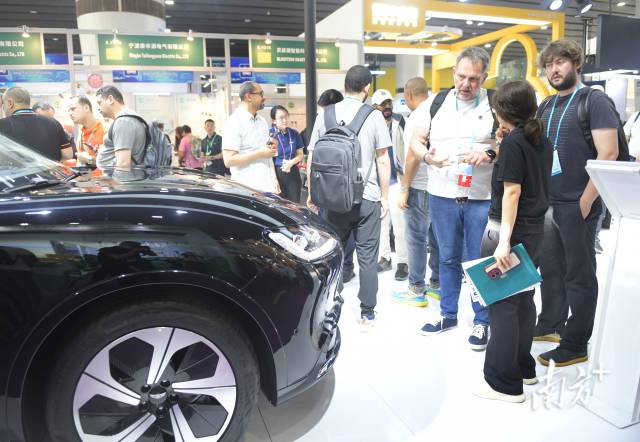 采购商在第135届广交会上了解新能源汽车。图源：新华社