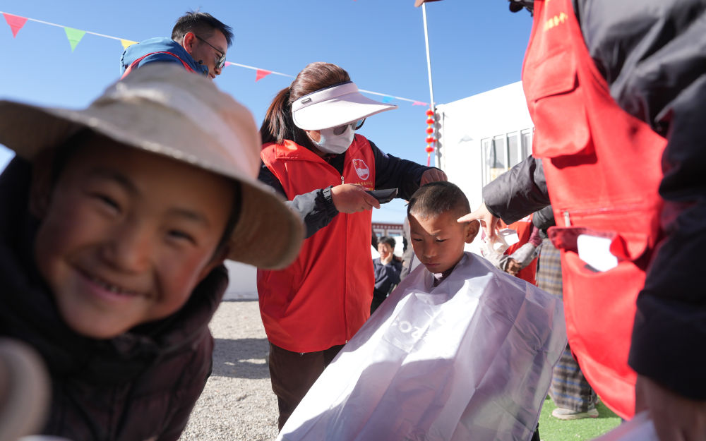 2025年1月26日,志愿者在西藏拉孜县吉如村安置点为孩子们理发。西藏定日县6.8级地震发生后,志愿者们迅速参与救援搜救、协助搭建帐篷、搬运赈济物资、协调村民所需。数百名大学生组成志愿者服务队,白天为安置点的孩子们辅导作业、陪孩子们运动;晚上组成巡逻队,守护安置点的安宁。