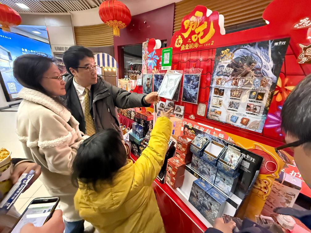 2月14日晚，在北京市海淀區(qū)的UME國(guó)際影城(華星店)，家長(zhǎng)帶著孩子挑選電影紀(jì)念品。新華社記者才揚(yáng) 攝