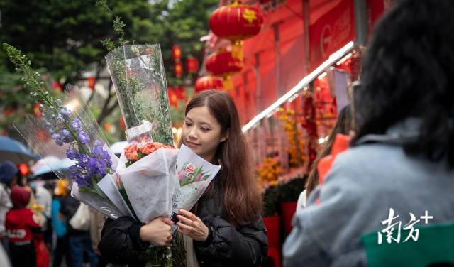 2月6日，广州越秀西湖花市，市民捧着满怀的鲜花拍照留念。