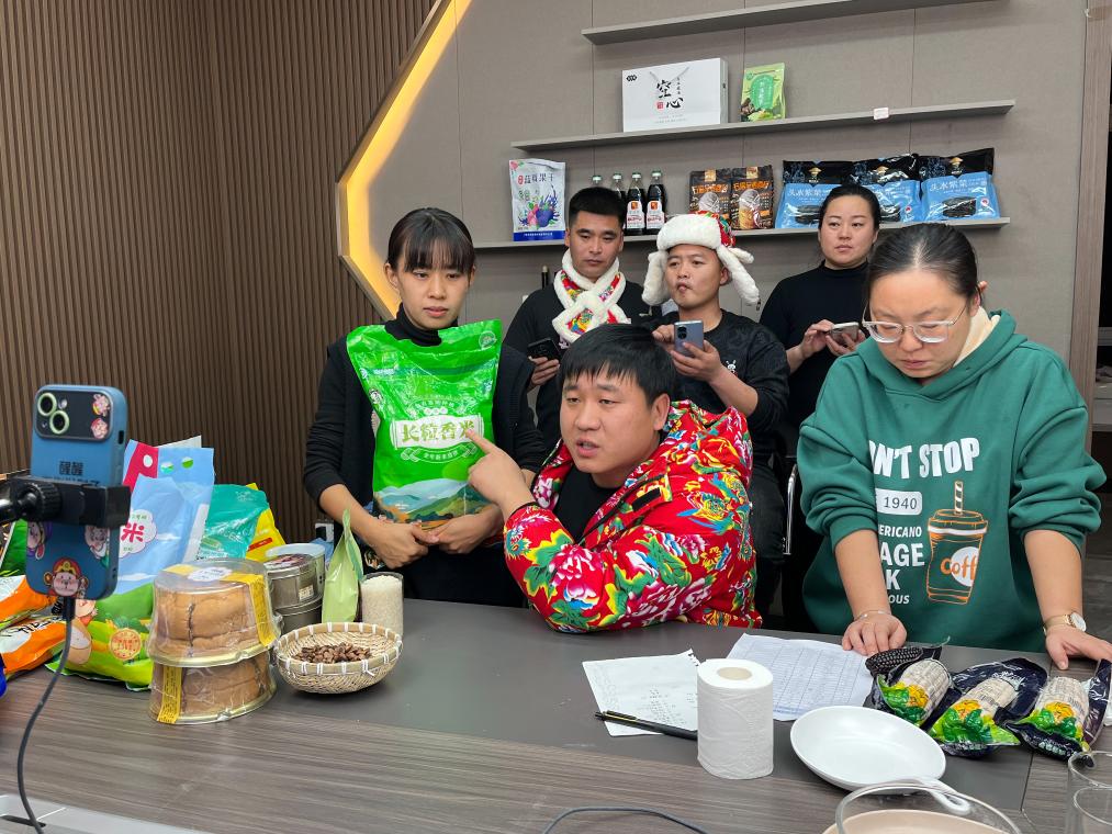 2023年12月15日，卢战开（前排中间）在直播销售大米。（受访者供图）
