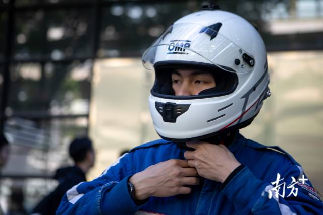 车手组组长罗胤龙正在穿戴赛车服。 