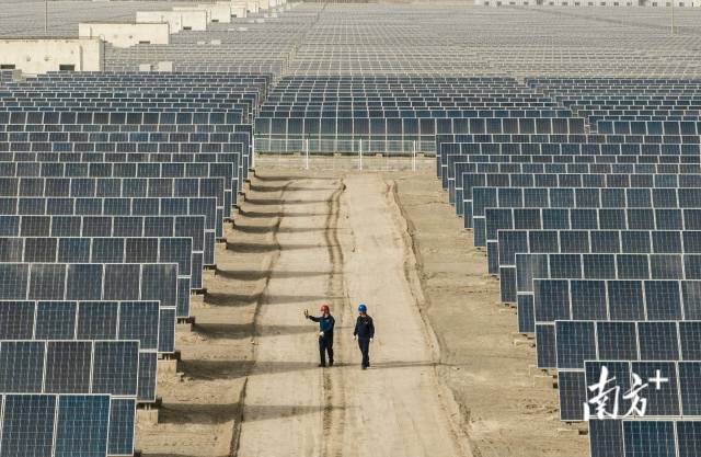 甘肃，中广核敦煌光伏电站建立在炙热的戈壁滩上，工作人员正用测温仪器检查光伏板温度。