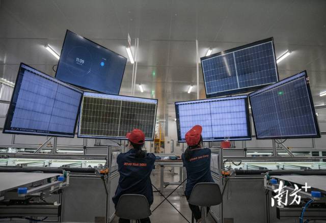 广东省潮州市，光伏生产车间内，工人正时刻盯着屏幕检查光伏板生产质量。