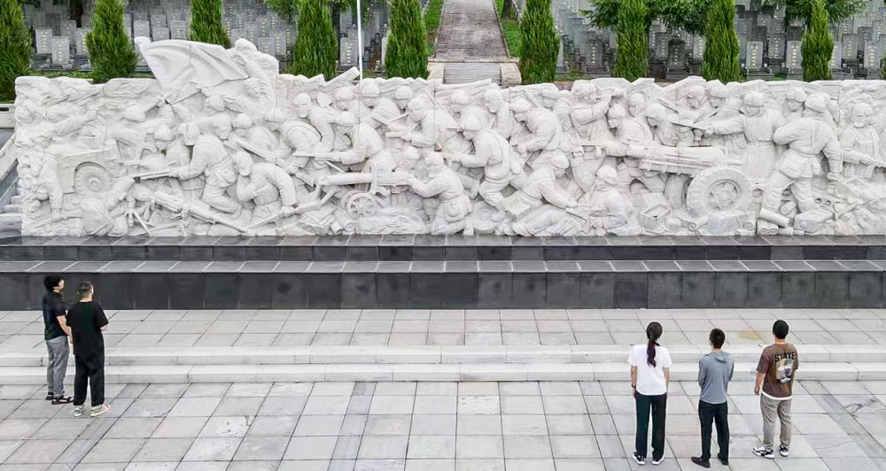 鸭绿江畔唱英雄 2023年7月13日,游客在吉林省集安市革命烈士陵园内观看抗美援朝烈士浮雕纪念墙(无人机照片) 。新华社记者 周万鹏 摄