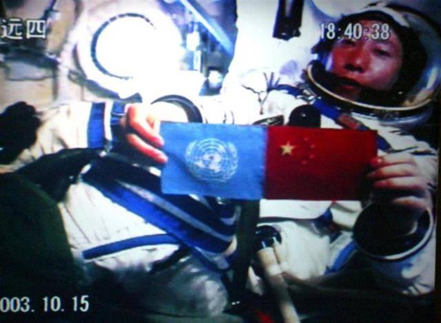 2003年中国航天员杨利伟在太空并列展示五星红旗和联合国旗。（新华社图）