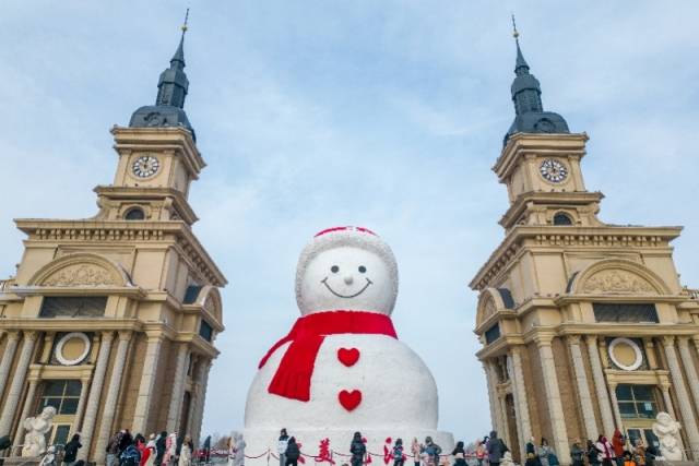 1月1日，在哈尔滨市群力音乐公园，众多游客前来与雪人合影。新华社发