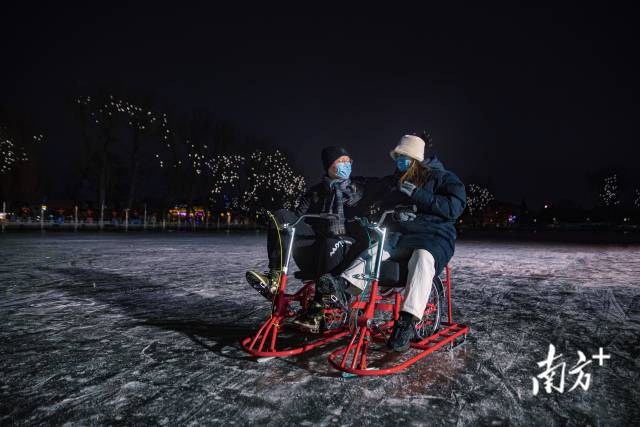 1月19日晚上，一对假期来北京游玩的情侣在什刹海冰场体验冰车。 