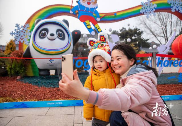 北京街头，2022年冬奥会吉祥物“冰墩墩” 成为大家喜欢的合影主角。 