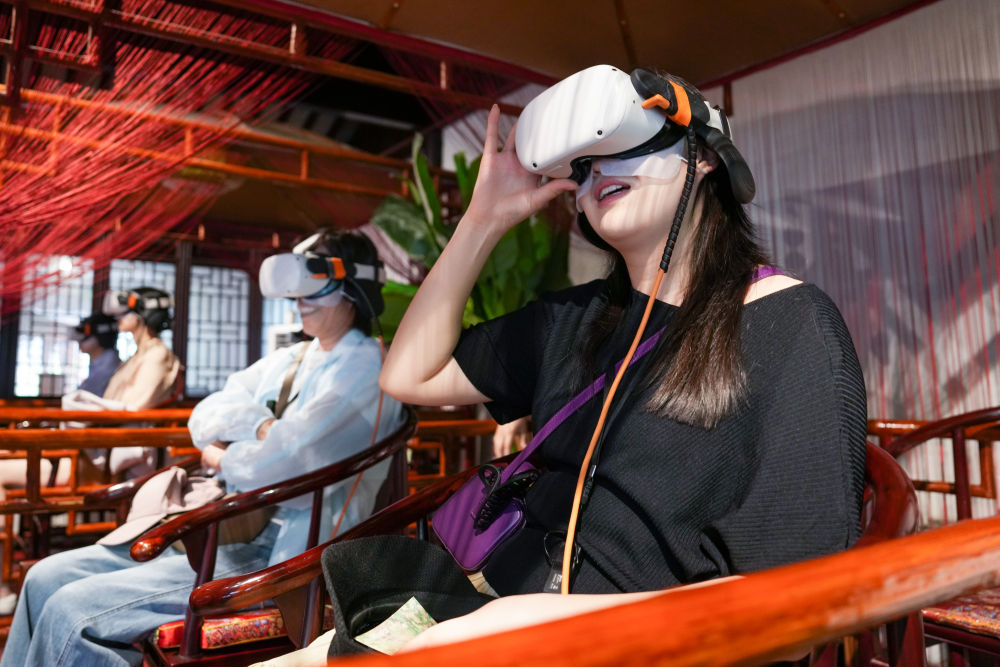   2025年5月18日，游客在江苏苏州拙政园体验VR漫游。近年来，苏州不断推进“数字园林”建设，在园林整体数字建模、园林要素数据库建设等方面开展探索，利用数字技术创造“数字云游”VR场景，打造“云游拙政园”“狮林园宇宙”“留园虚拟元宇宙”等项目，营造真实可感的虚拟空间，让观众沉浸式感受苏州园林的独特魅力。