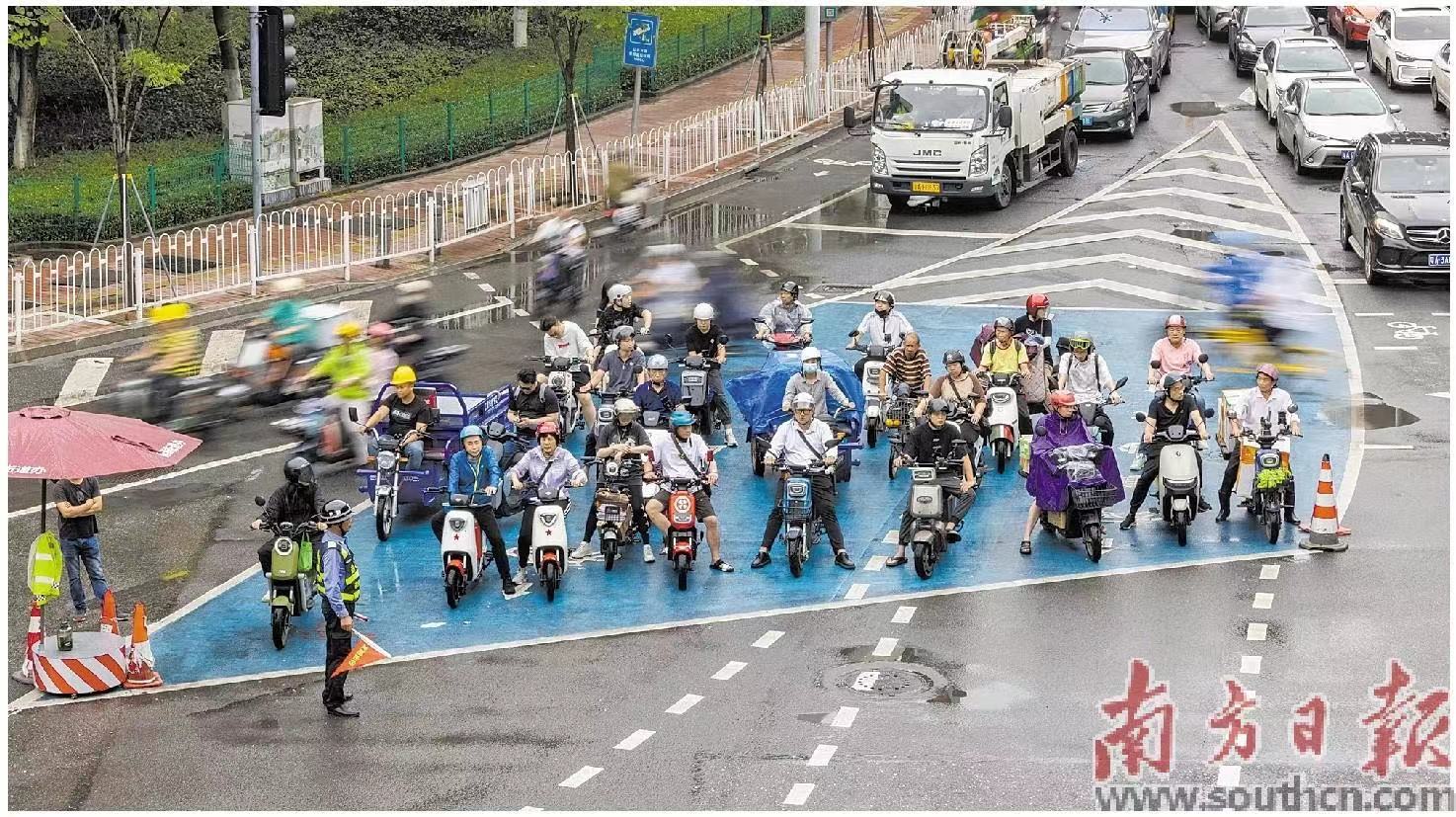 广州市荔湾区中山八立交，电动自行车在候车区域内等待通行。    