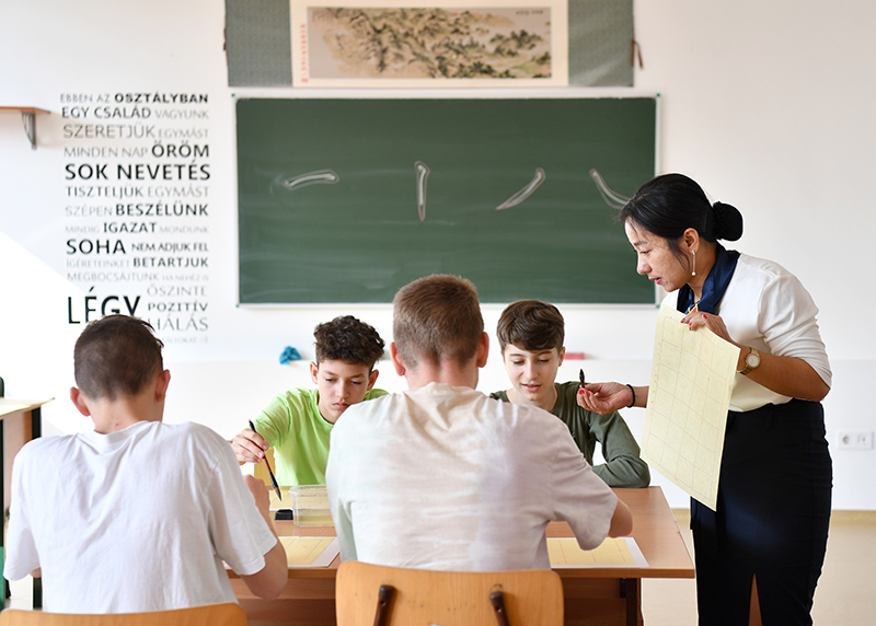 2023年2月24日，在匈牙利首都布达佩斯的匈中双语学校，中国教师指导学生们学习书法。