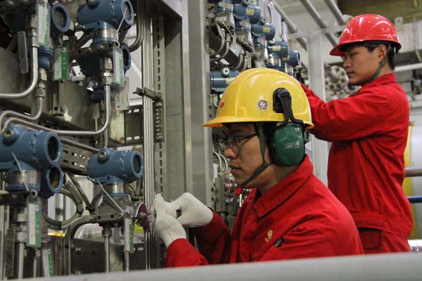 Workers calibrate sensitive systems on board an oil exploration project of CNOOC in Shanxi province.(Photo by Chen Yuanzi/For China Daily)