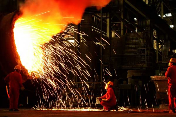 Workers clean a molten steel holder at Dalian Special Steel Co Ltd in Dalian, Liaoning province. (Photo: For China Daily/Liu Debin)