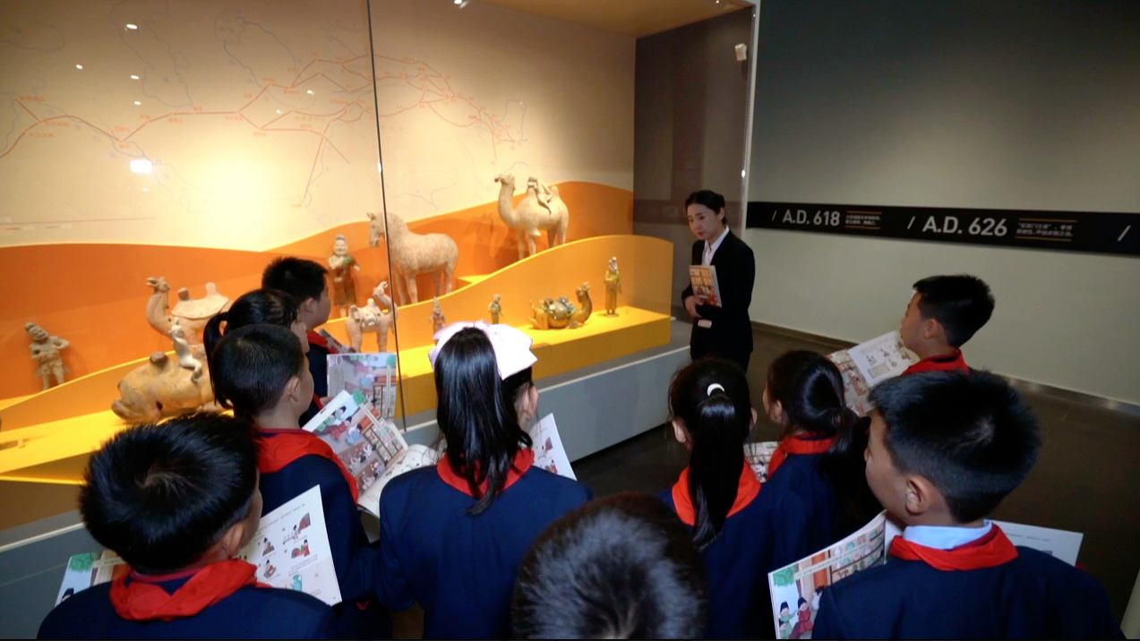 学生们带着西安博物院编制的社教读本参观展览(央广网发 张莉 摄)