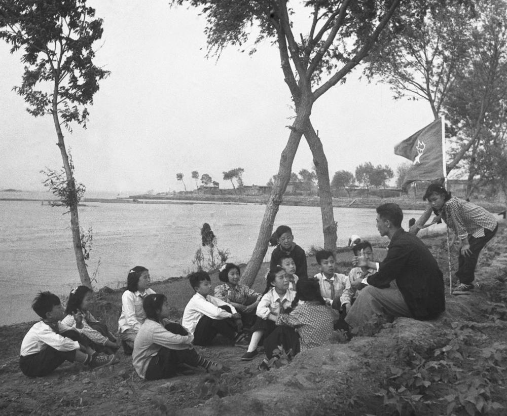 1955年，在河北白洋淀，新安小学的少先队员们听曾担任过抗战时期儿童团团长的陈殿元讲抗战故事。