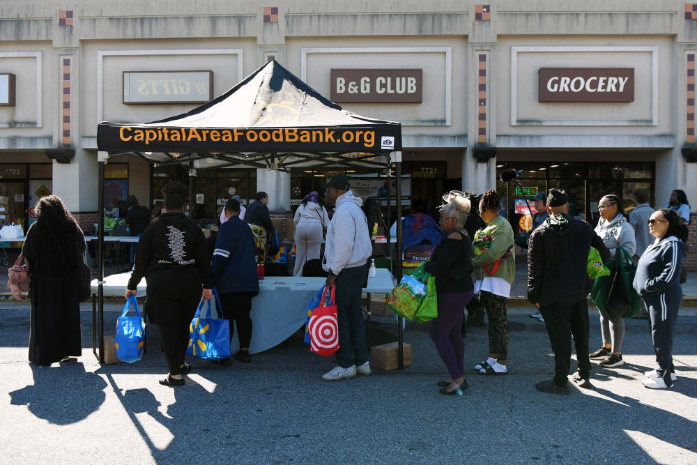 10月21日,在美国马里兰州海厄茨维尔市,联邦雇员排队登记领取免费食品。新华社记者李睿摄