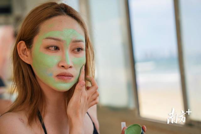 一位女性在冲浪前涂抹对海洋生物友好的防晒泥。 一位女性在冲浪前涂抹对海洋生物友好的防晒泥。