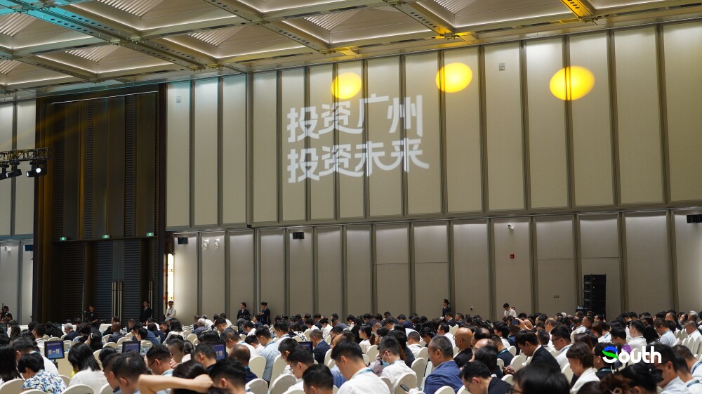 The slogan “Invest in Guangzhou, Invest in the future” is projected in Chinese on the wall.