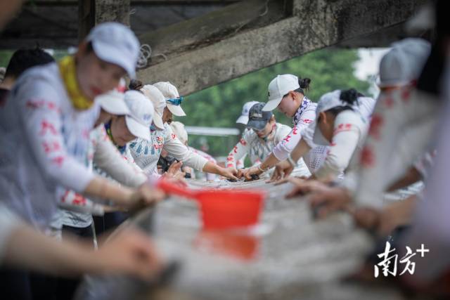 6月12日，进行完训练的队员们在教练组织下对龙舟进行清洗.. 