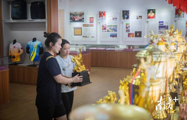 在基地荣誉室内，李雪和队友将荣誉奖杯摆放整齐。