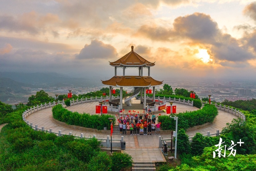 7月1日早上，阳江市金鸡岭公园的最高点上，市民挥舞着旗帜为伟大的中国共产党祝福。刘正亮 摄