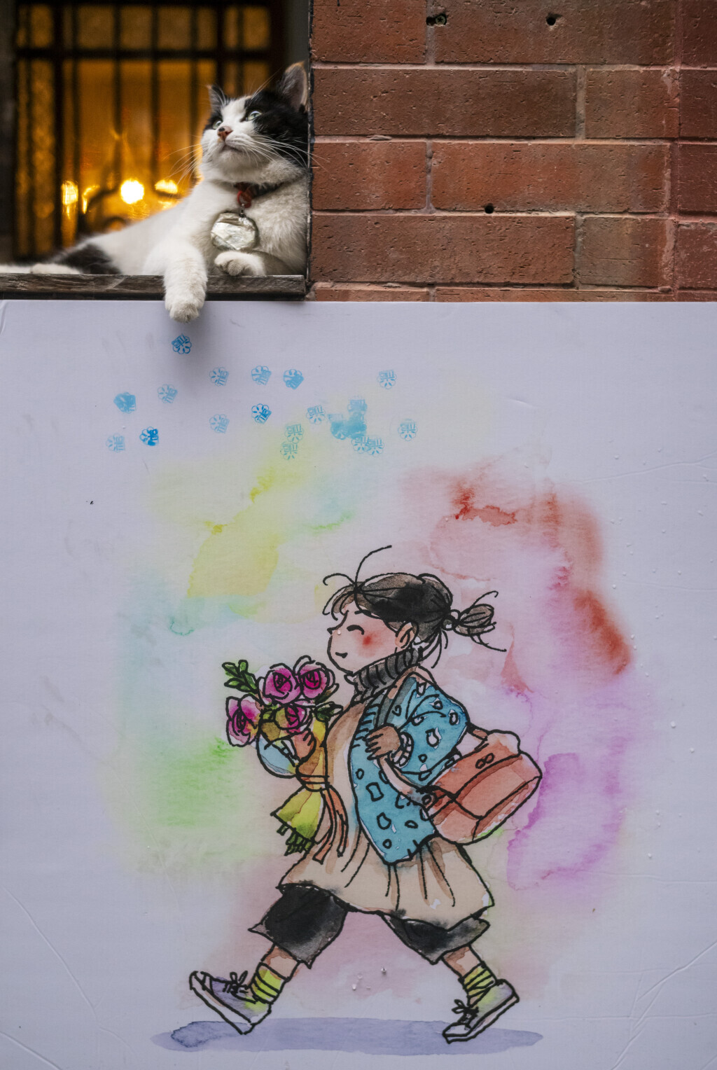 A cat poses on top of street artwork in Old Nanhai County Community on Liurong Street, Yuexiu District, Guangzhou, Guangdong