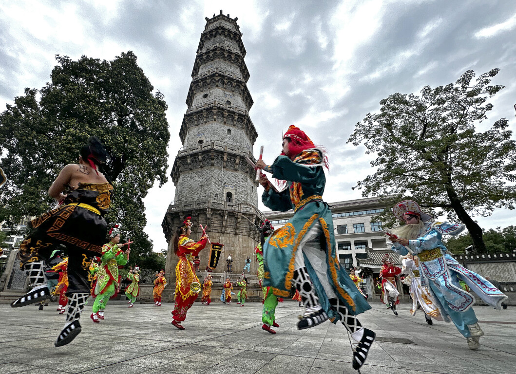 Performers present Yingge Dance with Shantou Chaoyang District's Wenguang Tower standing behind
