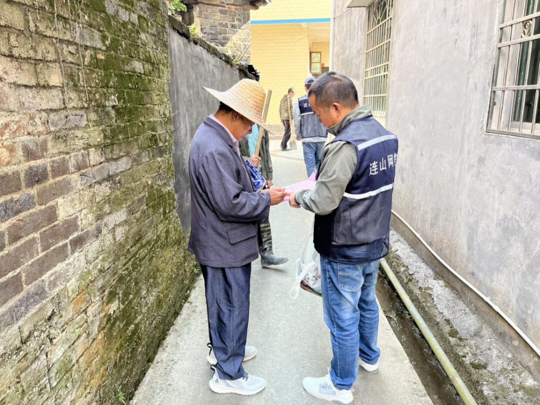 禾联村网格员向村民派发宣传手册。