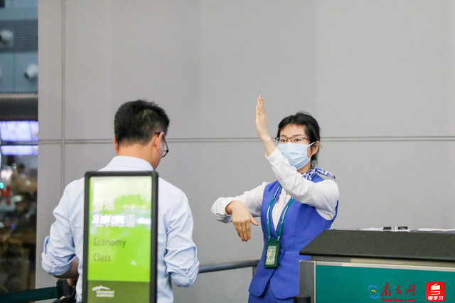 国内出港服务员引导旅客有序登机。