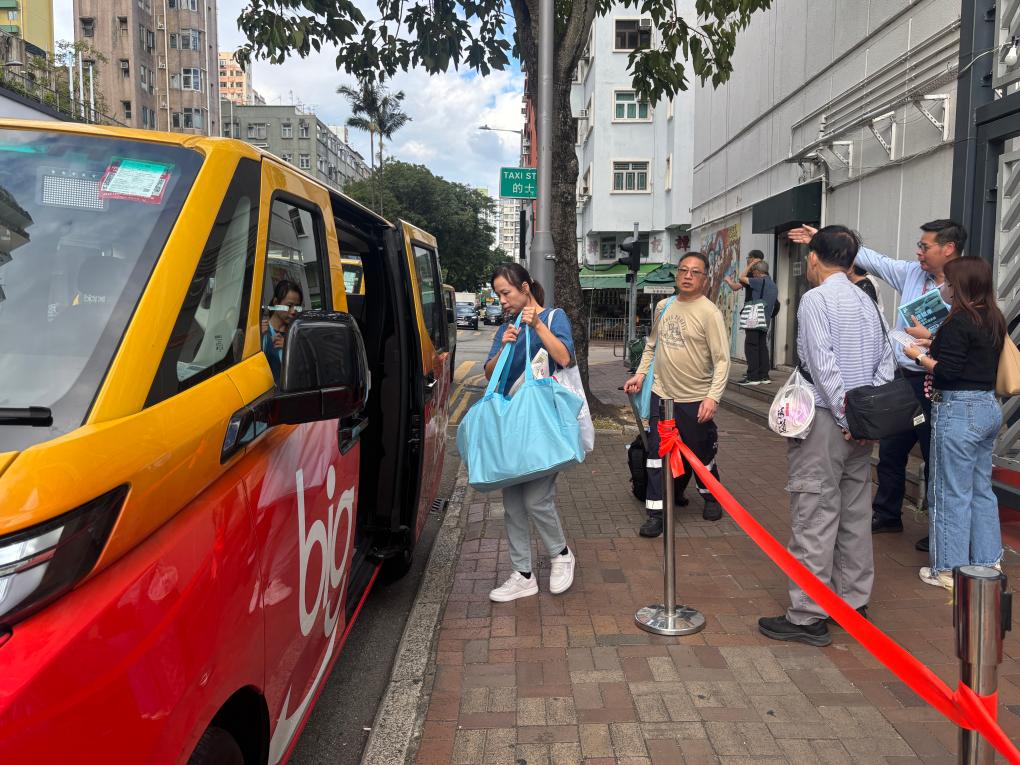 宏福苑受灾居民在庇护中心出来后,乘坐停靠在香港大埔社区会堂外的义载车辆(12月2日摄)。新华社发(许淑敏摄)