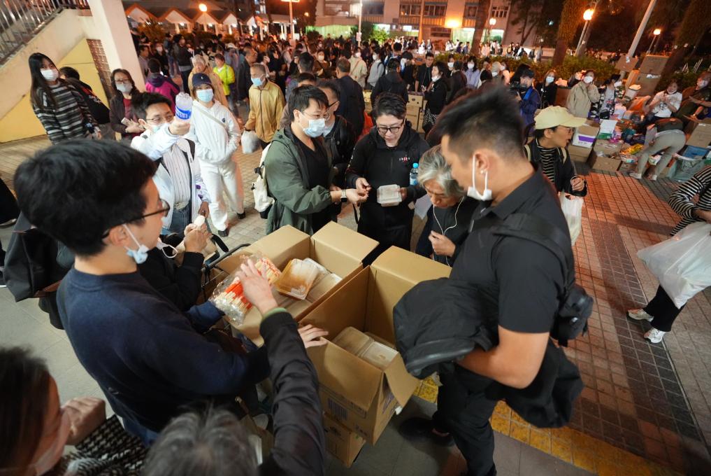 11月27日,义工在宏福苑附近向受火灾影响的市民派发物资。新华社发(吕小炜摄)