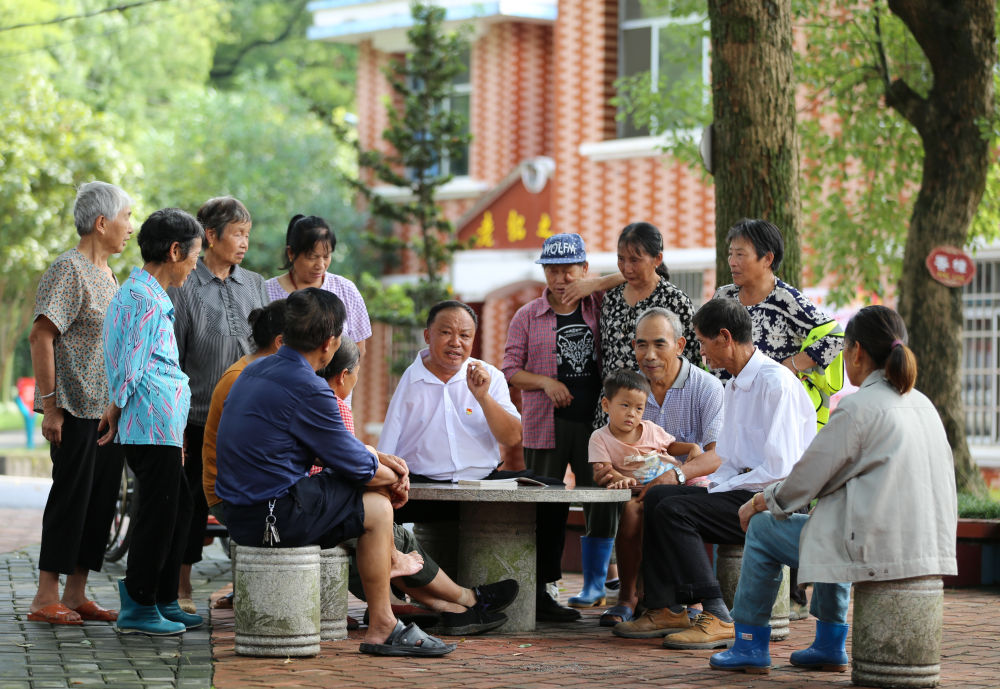 江西芦溪县宣风镇珠亭村人民调解员阳昌绍(中)为珠亭村的百姓宣讲民法典知识(2021年8月17日摄)。新华社记者 胡晨欢 摄