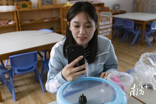 林洲健在班里与小朋友视频，在镜头前秀出课室里养的小乌龟。