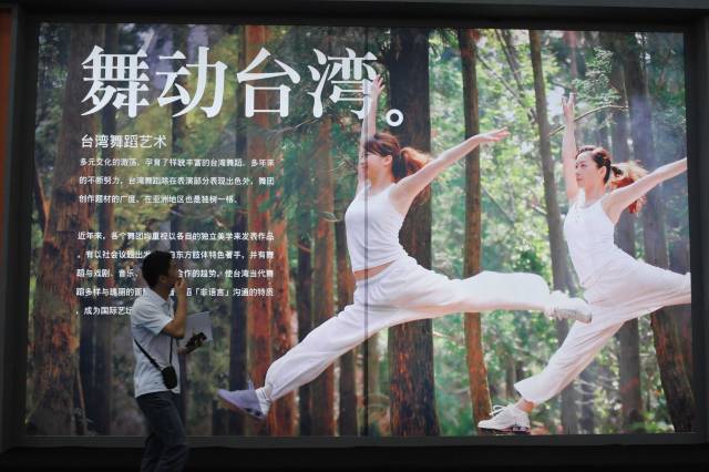 一位观众在深圳文博会台湾展馆中观看推介台湾舞蹈艺术的广告牌。新华社记者壮锦 摄于2009.5.15
