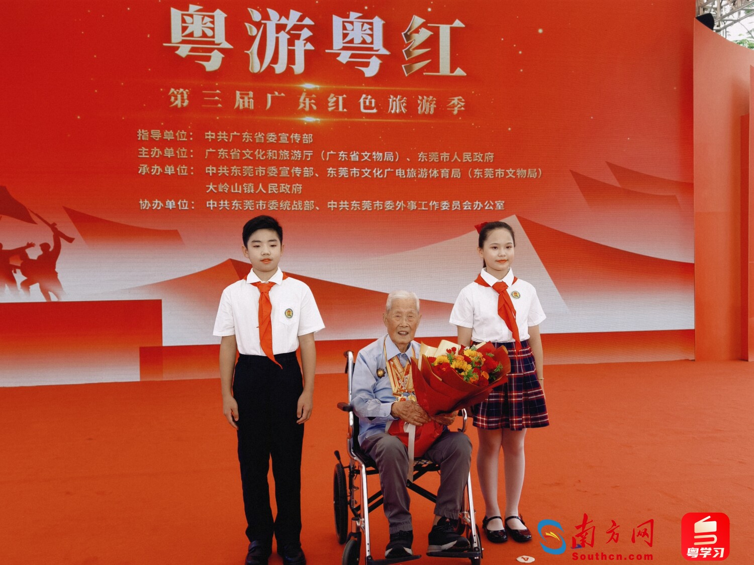 已过百岁的原东江纵队战士黎洪接受小朋友鲜花致敬