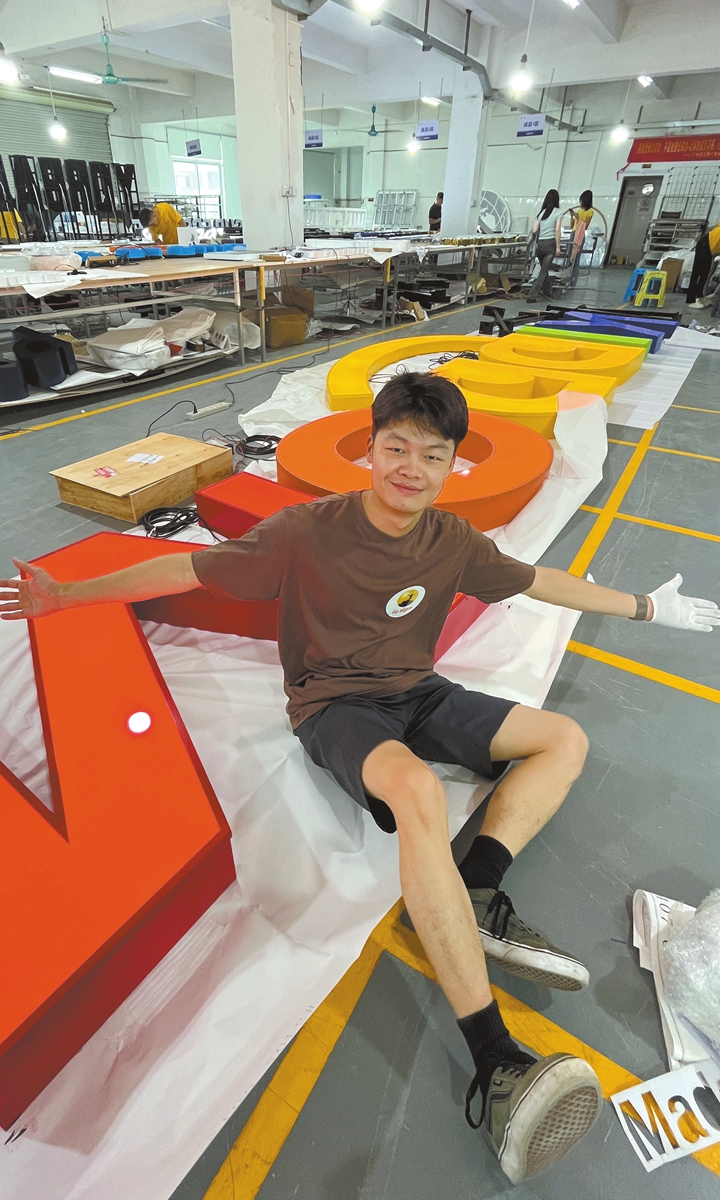 Zhu Yu poses in front of a giant LED sign. Photo: Courtesy of Lc Sign