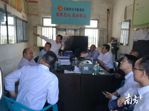 汕尾市税务局工作人员与村两委干部一起讨论扶贫规划。