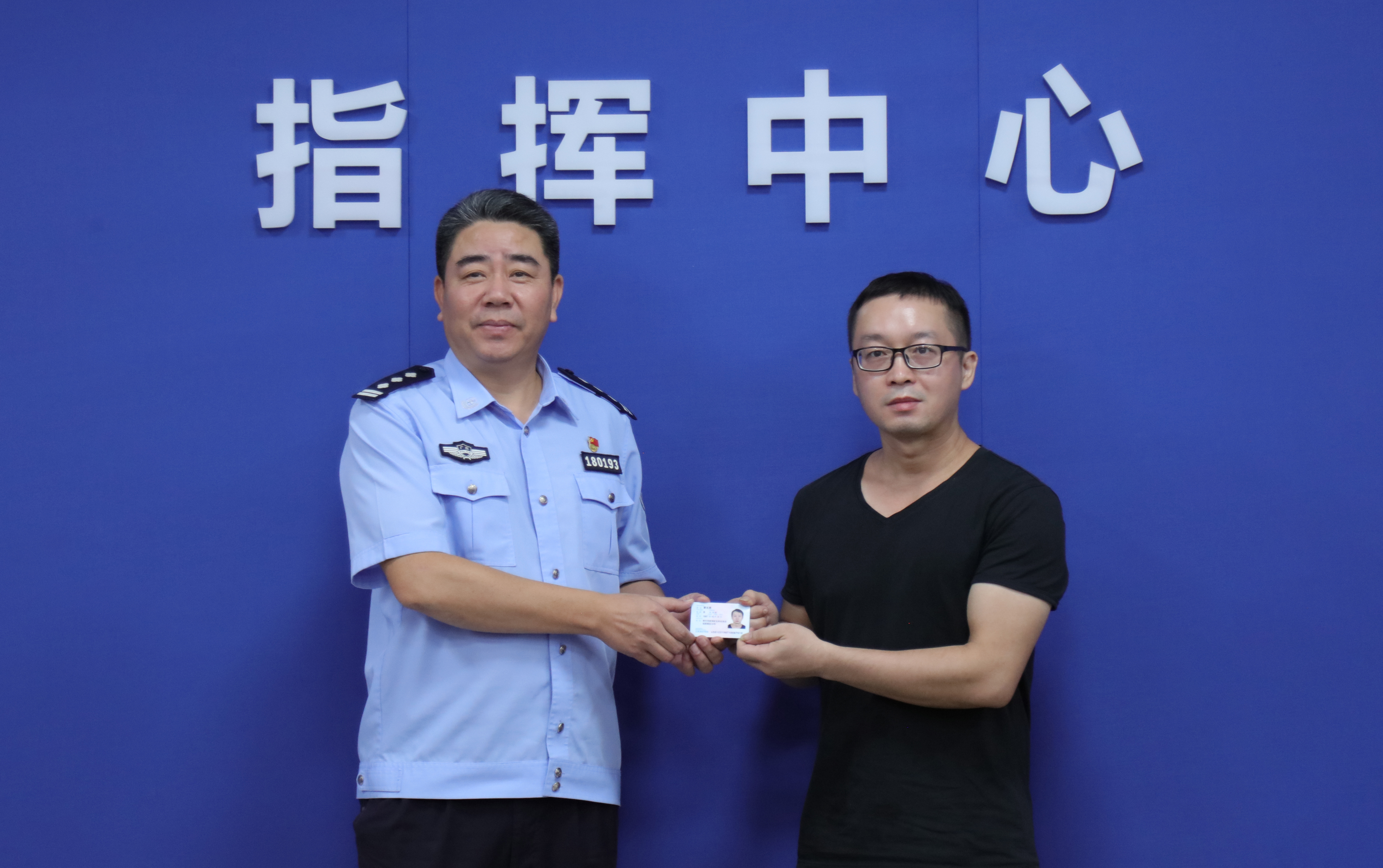 蒙志勇从广东佛山公安民警的手中接过自己崭新的身份证。