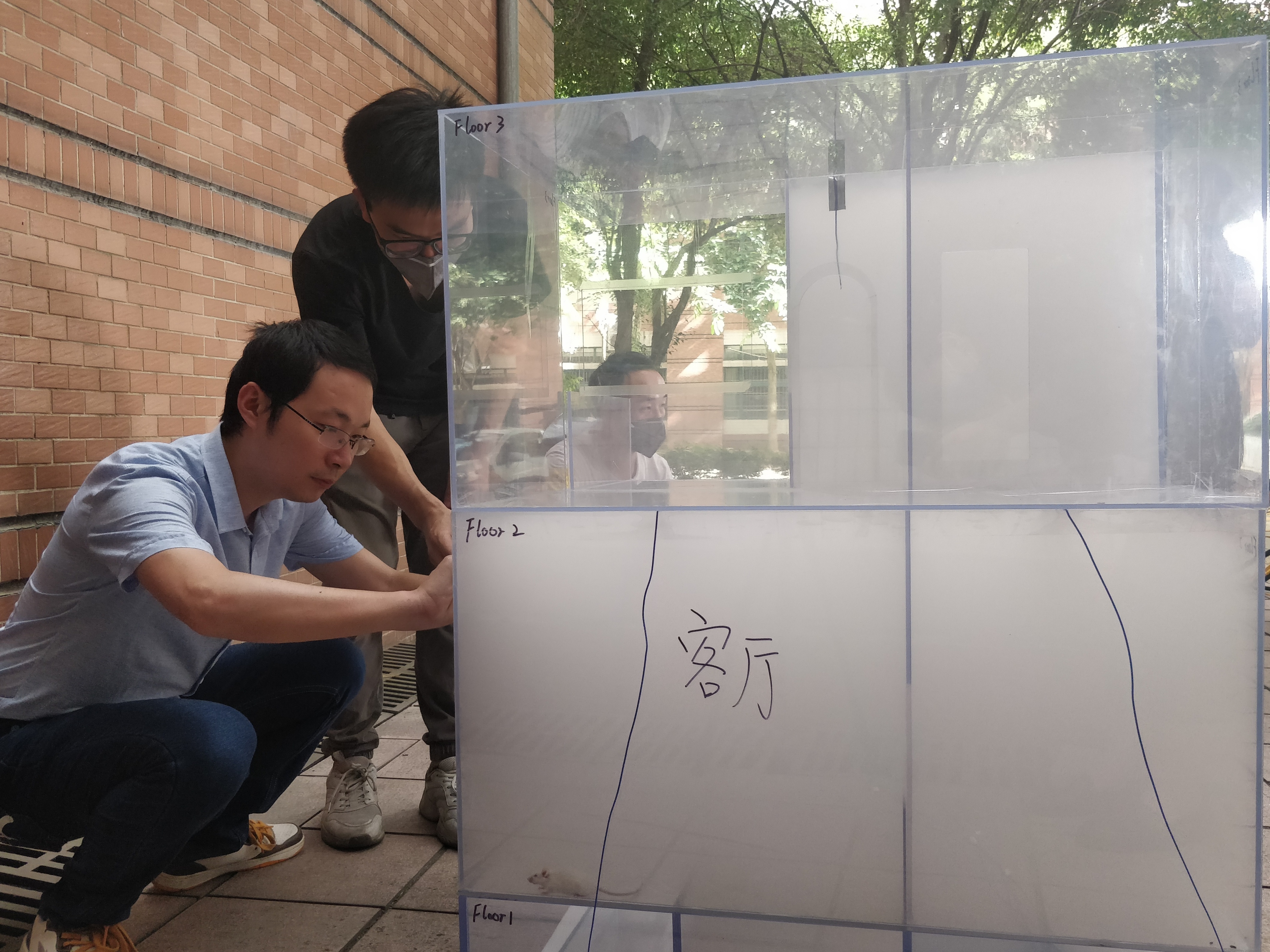 中山大学省消防科学技术重点实验室团队按照比例制作了起火民居的模型，进行烟雾测试。