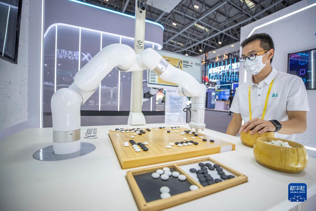 8月21日，2022智博会科大讯飞展厅的工作人员演示与弈棋机器人对弈。新华社记者 黄伟 摄