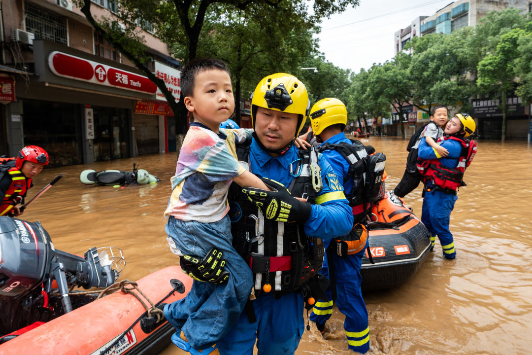 2024年7月2日，在平江县大桥西路附近，蓝天救援队队员在转移群众（图：新华社）