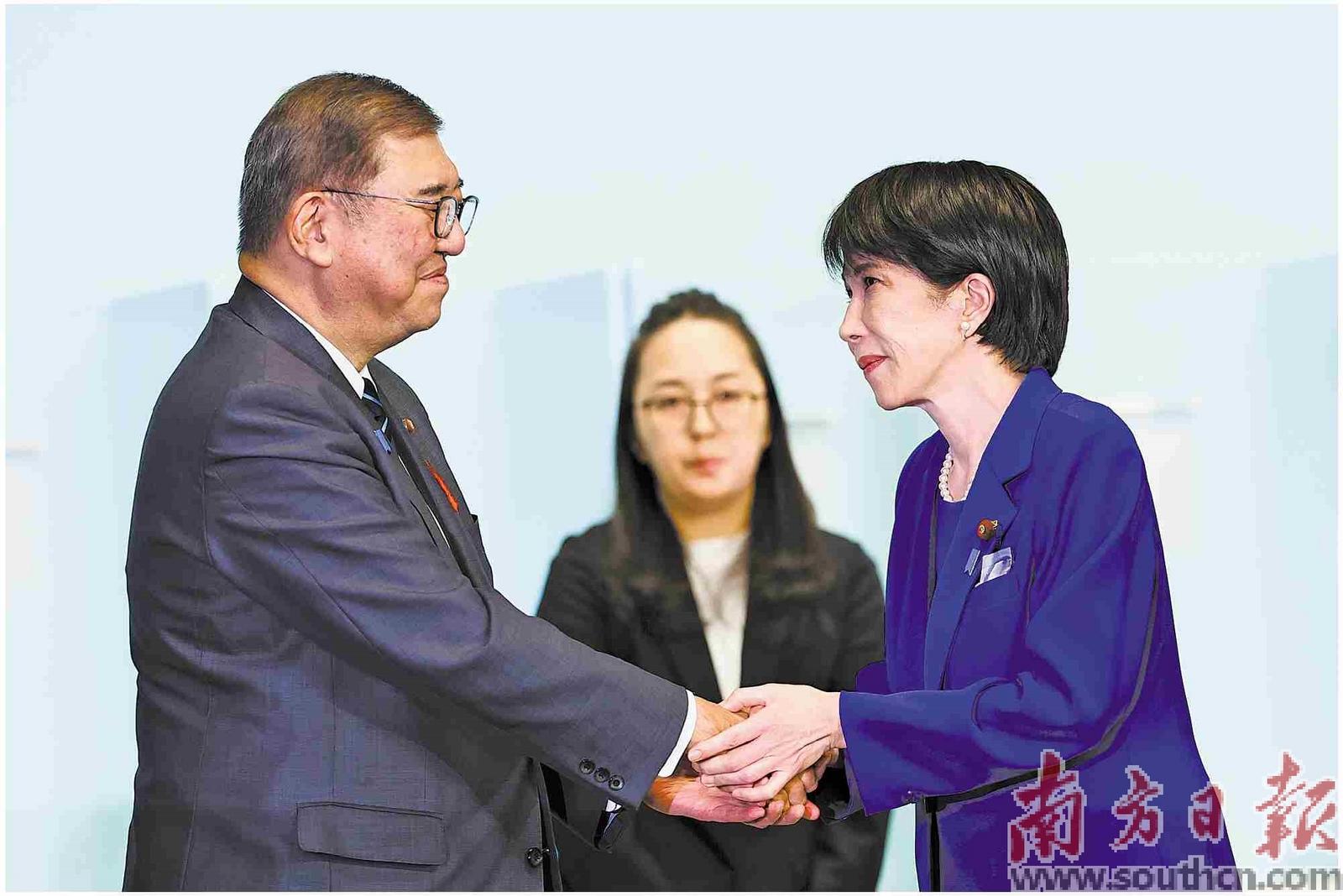 在日本东京的自民党总部，高市早苗（右）在自民党总裁选举中胜出后向日本首相、自民党前任总裁石破茂（左）致意。新华社发