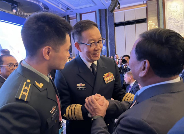 2024年5月31日香会开场晚宴，中国防长董军与印尼当选总统、国防部长普拉博沃握手。图/娄晓希