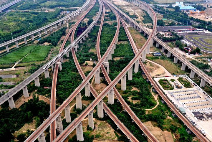 2024年5月30日拍摄的河南省郑州东站附近纵横交错的高铁线路（无人机照片）。随着2022年6月济（南）郑（州）高铁濮（阳）郑（州）段开通运营，河南“米”字形高铁网勾画成型，以郑州为中心，高铁通达全国，形成覆盖周边省会城市、京津冀城市群的2个半小时经济圈，覆盖长三角、粤港澳大湾区、成渝地区双城经济圈的4小时至6小时经济圈。